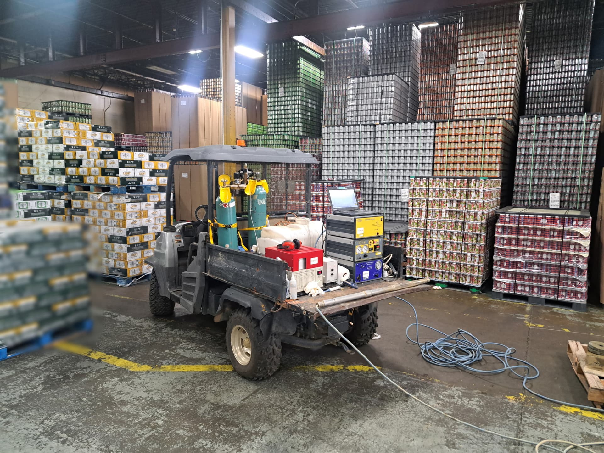 A utility vehicle carrying the HRSC acquisition rack, parked and logging between stacked pallets inside a working warehouse