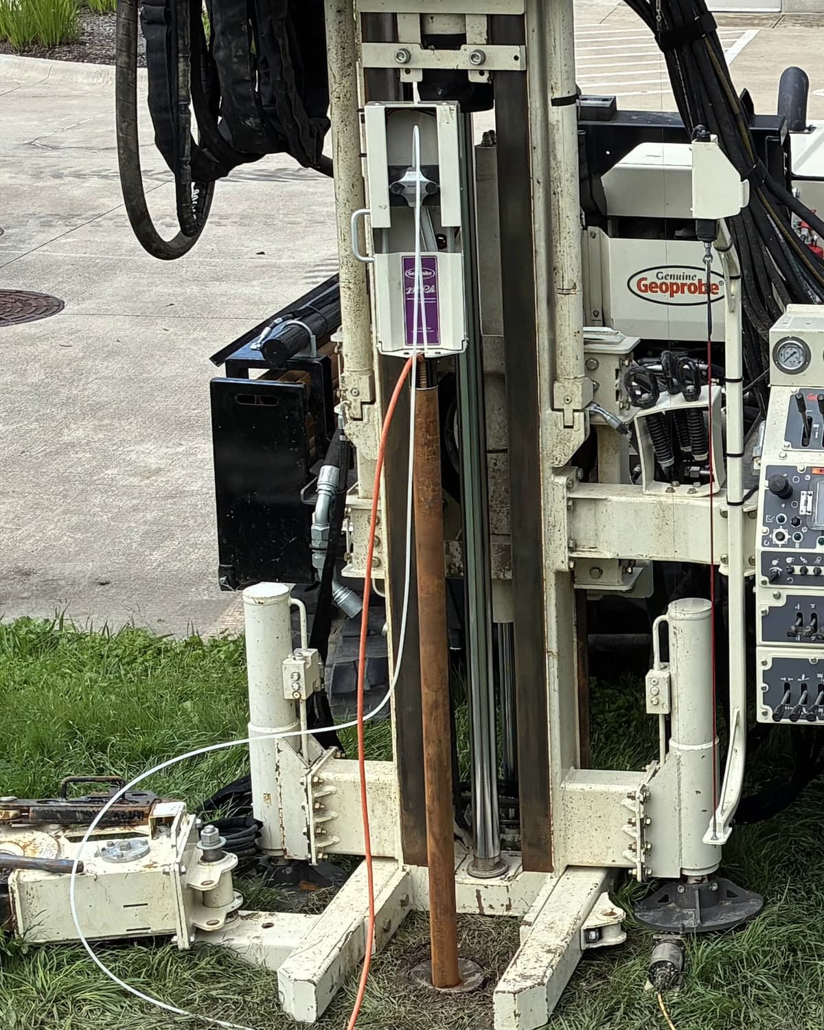 A pump actuator mounted on top of the 2.25 in. rods of an HPT Groundwater Sampler, beside the orange HPT trunkline